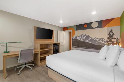 a bedroom with a bed and a desk with a television at Best Western Plus Clocktower Inn in Billings