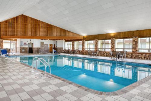 a large swimming pool with blue water in a building at Best Western Tomah Hotel in Tomah