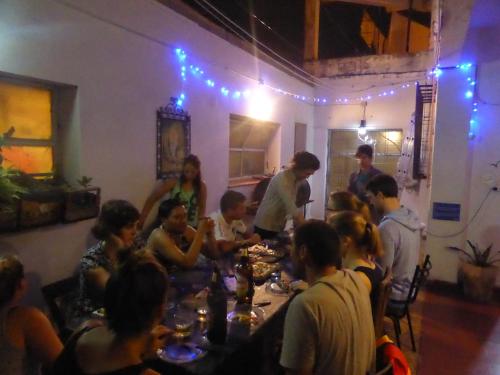un grupo de personas sentadas alrededor de una mesa en una habitación en mate! Hostel en Córdoba