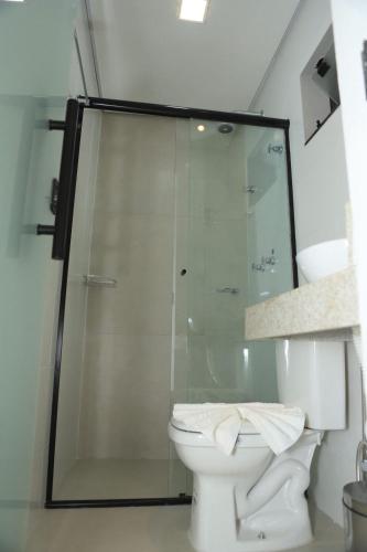ein Badezimmer mit Toilette und Glasdusche in der Unterkunft Mairí Hotel in Itaituba