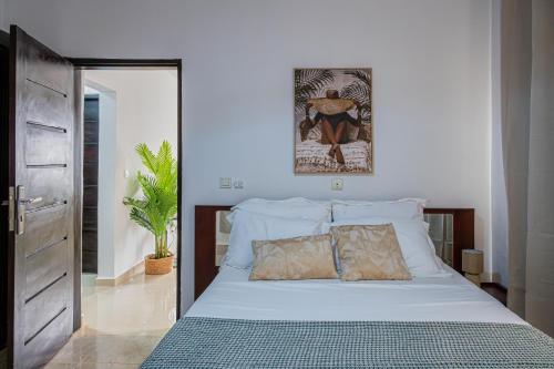 ein Schlafzimmer mit einem weißen Bett und zwei Kissen in der Unterkunft La villa five star in Azuretti