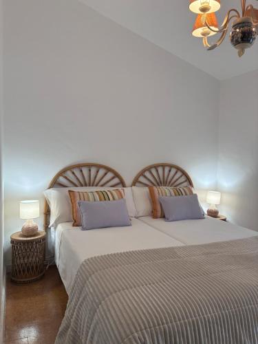a bedroom with a large bed with two pillows at O lar da praia in Corcubión