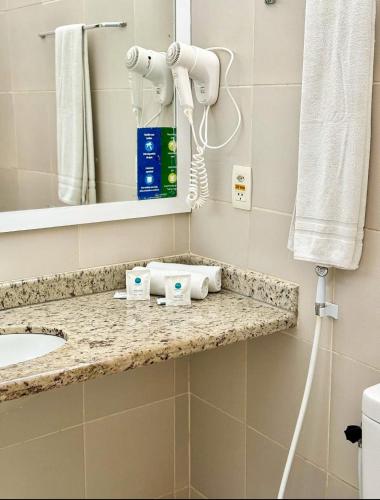 a bathroom with a sink and a mirror at Coqueiros Express Hotel in Maceió
