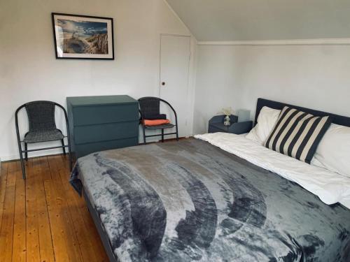 a bedroom with a large bed and two chairs at Schwedenhaus-Nykroppa in Nykroppa