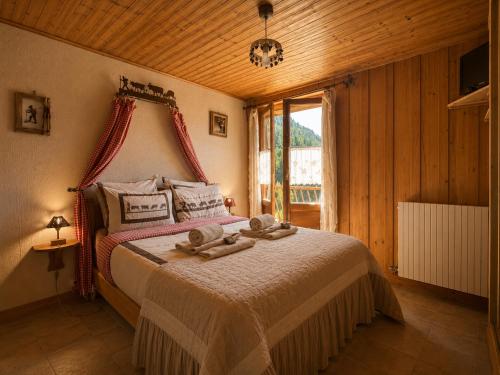 a bedroom with a bed with towels on it at Chalet Génépi in Montriond