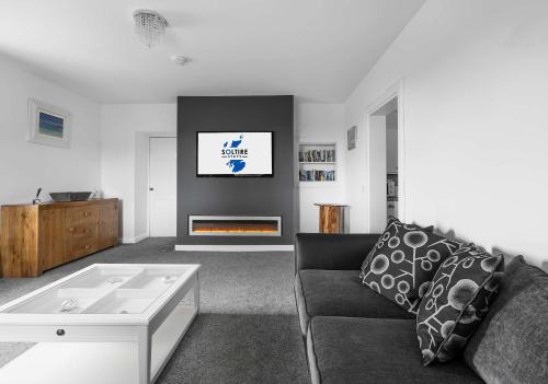 a living room with a couch and a fireplace at Dunallan Farm Cottage with Optional Hot Tub & Stunning Views in Island of Bute