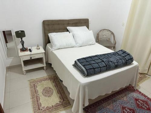 a bedroom with a bed and a table with a mirror at veleiros g3 in Ibiúna