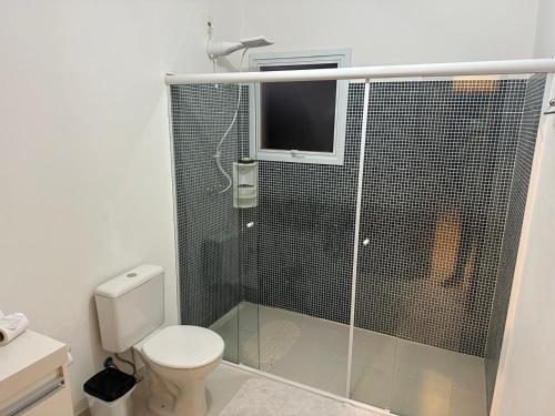 a bathroom with a toilet and a glass shower at veleiros g3 in Ibiúna