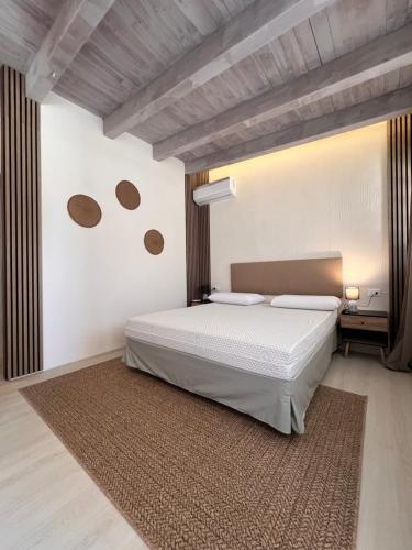 a bedroom with a white bed and a brown rug at B H Lampedusa in Lampedusa