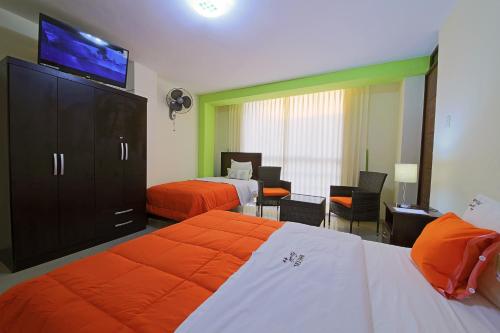 a hotel room with two beds and a flat screen tv at Hostal Florida in Chiclayo