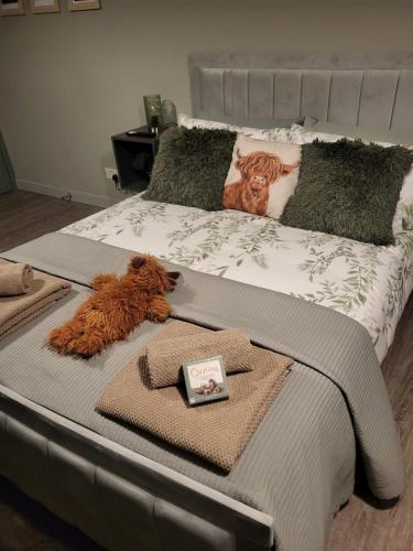 a bed with two teddy bears and towels on it at Holmleigh Place in Buxton