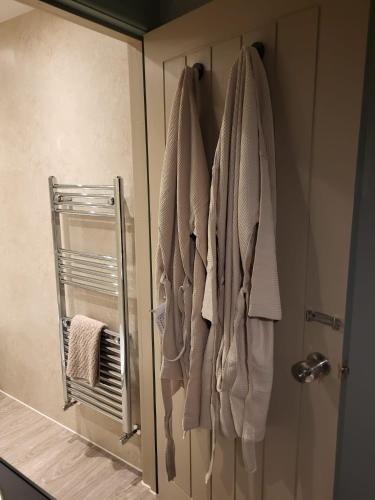 a bathroom with towels hanging on a shower door at Holmleigh Place in Buxton