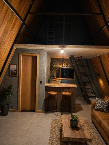 a living room with a kitchen and a bar in a house at Chalés parada ideal in Guapimirim