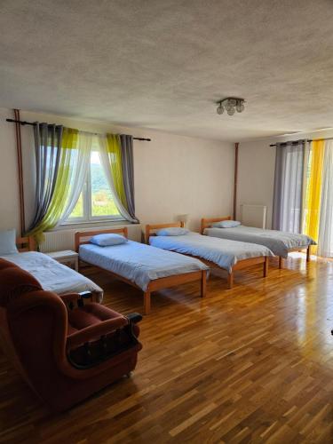 a room with four beds and a couch in it at M&M Bazen resort Goražde in Goražde