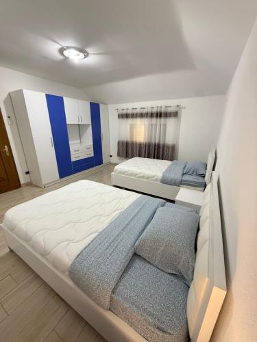 a large white bedroom with two beds in it at Skyline Villa Boge in Bogë