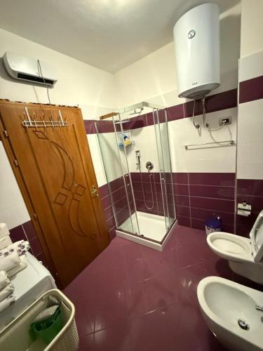 a bathroom with a shower and a toilet and a sink at Skyline Villa Boge in Bogë