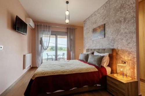 a bedroom with a large bed and a balcony at Valentina's Luxe Apartment in Mastihari