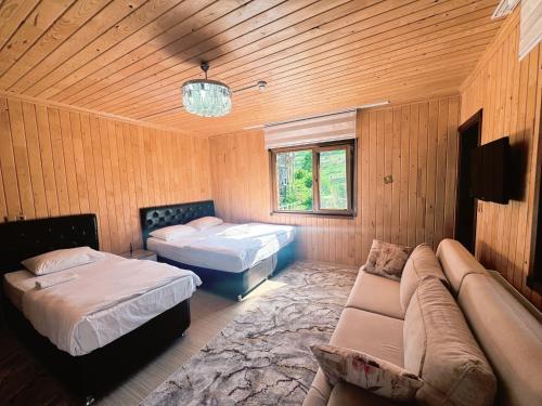 a room with two beds and a couch in it at Yüce Suite in Uzungöl