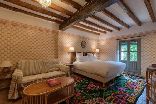 a bedroom with a bed and a couch and a table at Casa Rural Palacio Armiñón in Armiñón