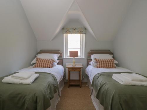 two twin beds in a room with a window at Middle Cottage in Salisbury