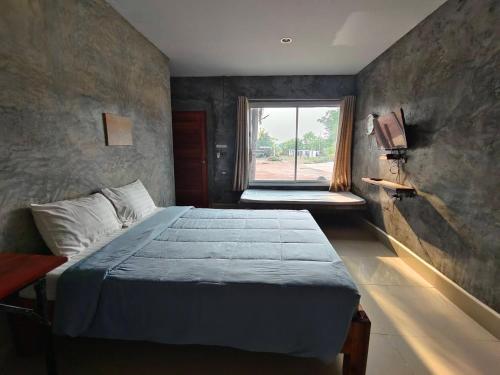 a bedroom with a large bed and a window at Dungkaew lakeview resort in Amphoe Ban Dung