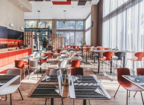 a restaurant with tables and chairs and windows at Parc app in Mohammedia