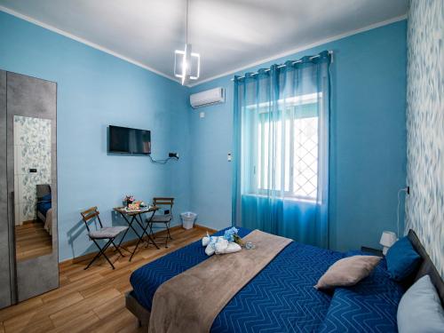 a blue bedroom with a bed and a table at B&B Son De Mar in Salerno