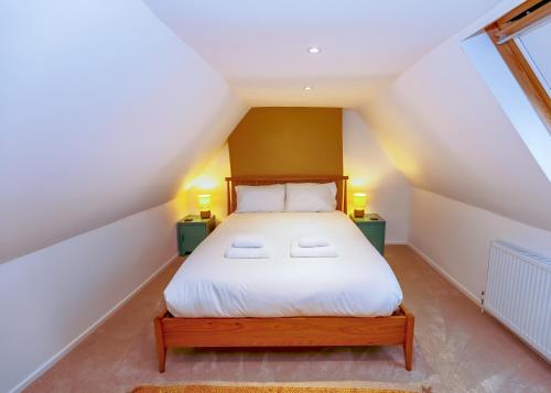 a bedroom with a white bed in a attic at Cottage on Wells High Street in Wells