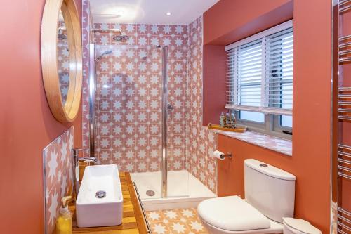 a bathroom with a shower and a toilet and a sink at Cottage on Wells High Street in Wells
