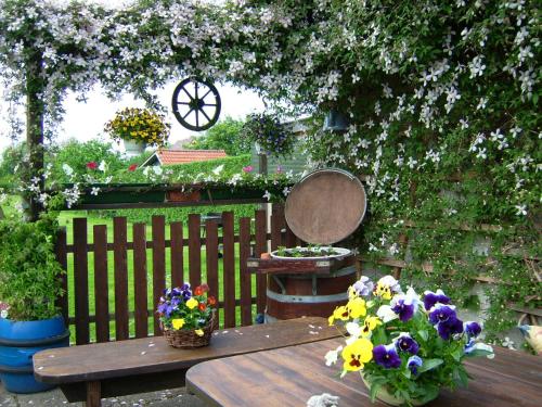 a wooden table with flowers on it next to a fence at Ferienwohnungen in Semlow in Semlow