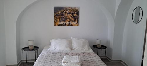 a bedroom with a bed with two tables and a picture on the wall at Elvasguesthouse in Elvas