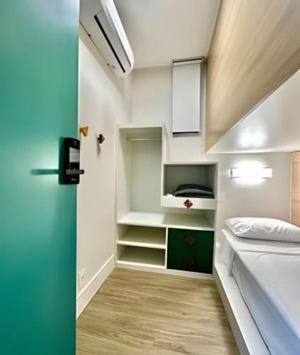 a small room with a bed and a closet at Quartos individuais vila olimpia in São Paulo