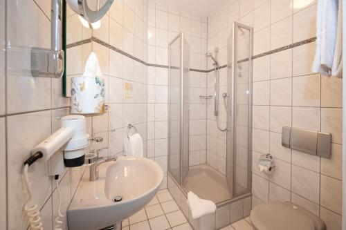 a bathroom with a shower and a sink and a toilet at Hotel Bären in Schramberg