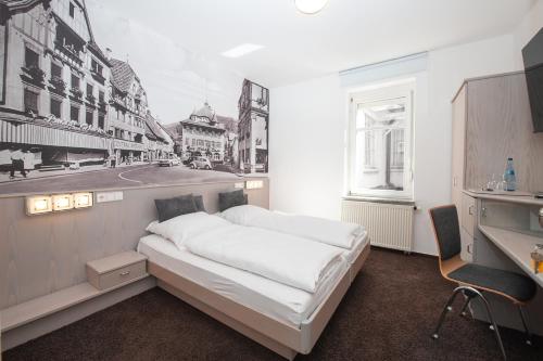 a bedroom with a white bed in a room at Hotel Bären in Schramberg