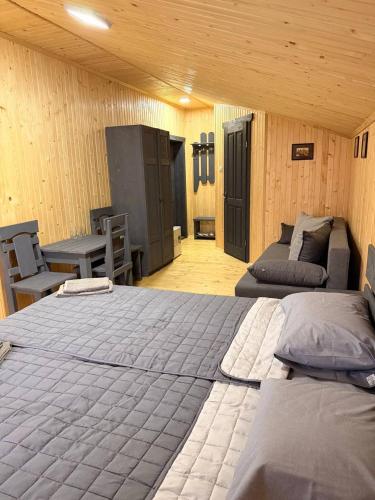 a room with two beds and a table and chairs at Садиба ВидНа in Kvasy