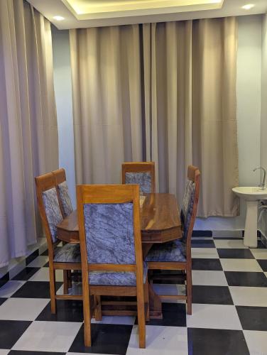 a dining room with a table and chairs on a checkered floor at Eden Vista Stays in Dar es Salaam