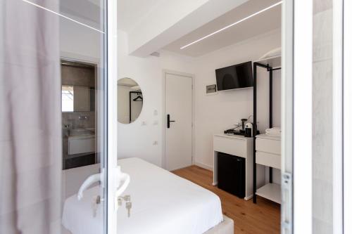 a white bathroom with a sink and a mirror at Ionio Blue in Himare