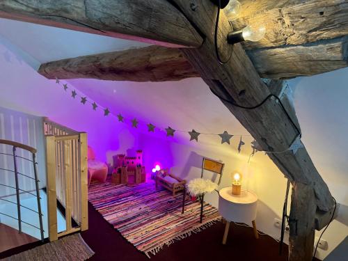 a living room with purple lights on the ceiling at La MaisonneTTe d'ElodibiZa ! in Moret-sur-Loing