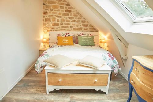 a bedroom with a bed in a attic at Ker Adèle, longère cosy au cœur d'un bois in Ploërdut