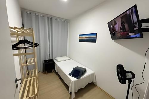 a room with a bed and a television on the wall at Quartos individuais Vila Olimpia 1 in São Paulo