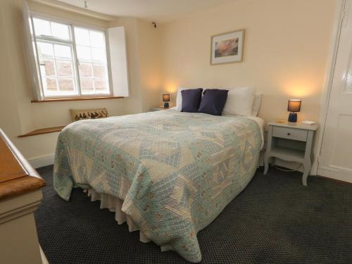 a bedroom with a large bed and a window at Crantock in Sherborne