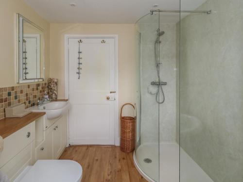 a bathroom with a shower and a toilet and a sink at Crantock in Sherborne