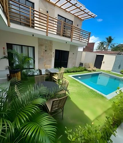 a patio with a table and chairs and a swimming pool at Petit da Pipa Studios Privados in Pipa