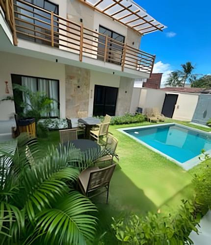 a backyard with a swimming pool and a house at Petit da Pipa Studios Privados in Pipa