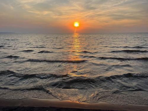 a sunset over the ocean with the sun setting at Riverside Haven on Georgian Bay in Wasaga Beach