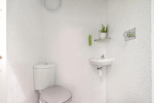 a white bathroom with a toilet and a sink at 1 Bed in Bude oc-s34849 in Bude