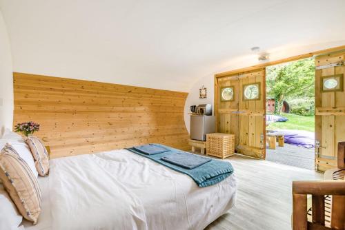 a bedroom with a large bed with a wooden wall at 1 Bed in Bude oc-s34847 in Bude