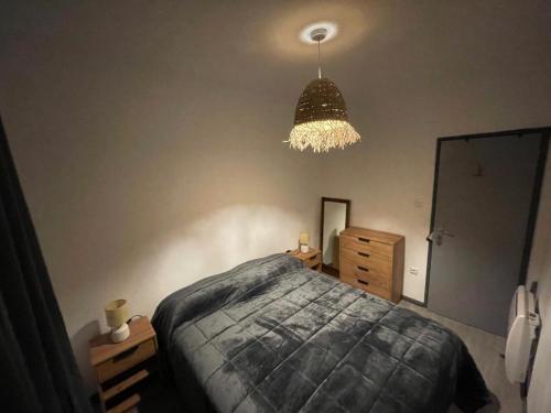 a bedroom with a bed and a chandelier at Maison Casa Nord du Portugal Gères in Arcos de Valdevez