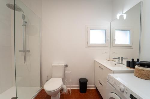 a white bathroom with a toilet and a shower at Au 212, T2 moderne et confortable in Mont-de-Marsan