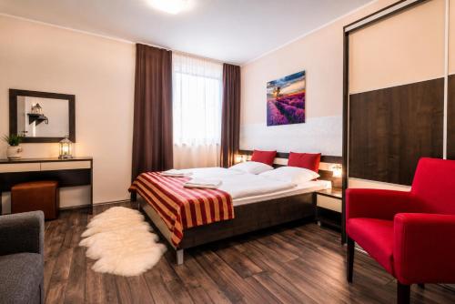 a hotel room with a bed and a red chair at Komnata Bešeňová - Dvojizbový Apartmán 261 in Bešeňová